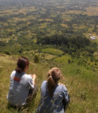 Sachi rests at the top of a hike with a fellow teacher, looking out over Yetebon.