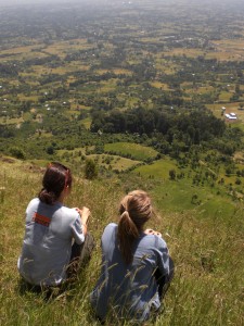 Sachi rests at the top of a hike with a fellow teacher, looking out over Yetebon.