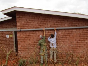 Stephen and his father look at fixing a pipe when his parents visited him at Nyumbani.